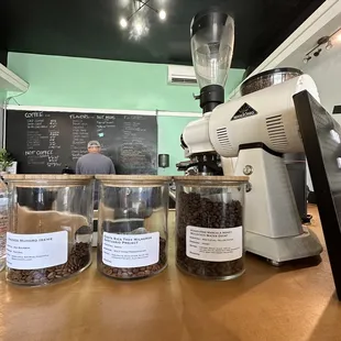 a coffee grinder and jars of coffee beans