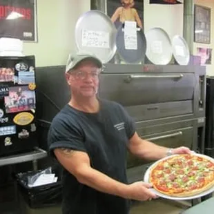 a man holding a pizza