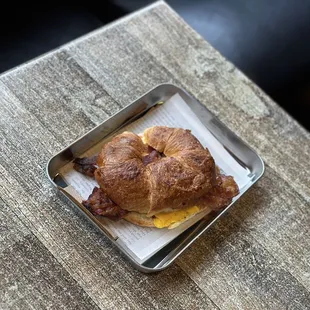 a croissant sandwich on a tray