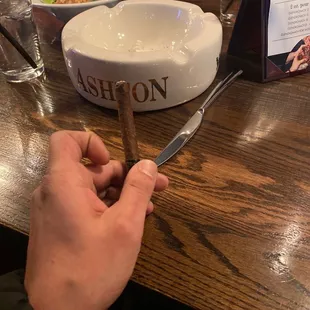 a person cutting a cigar