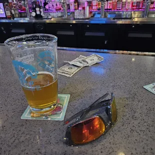 a pair of sunglasses and a pint of beer