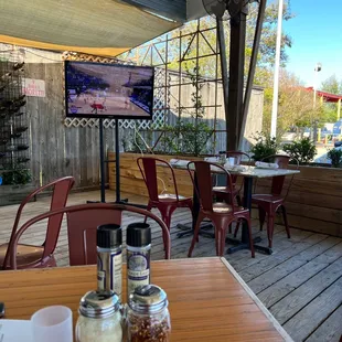 a patio with tables and chairs and a flat screen tv