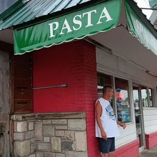 a man standing in front of a restaurant
