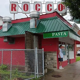 a man standing in front of a restaurant