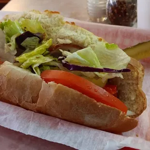 a hot dog with lettuce and tomatoes