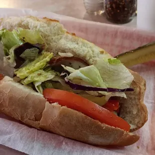 a hot dog with lettuce and tomatoes