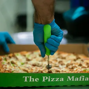 a person cutting a pizza