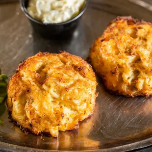 two crab cakes on a plate with lettuce