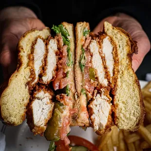 a person holding a cut in half sandwich