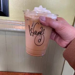 a hand holding a cup of iced coffee