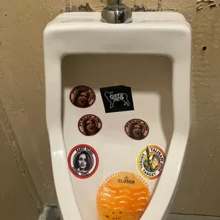 a urinal with stickers on it
