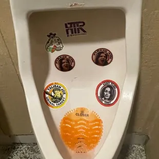 a urinal with stickers on it