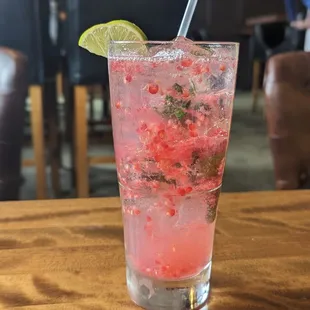 a pink cocktail with a lime garnish