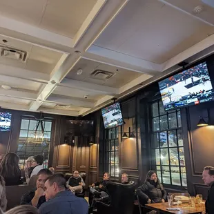 people sitting at tables and watching televisions
