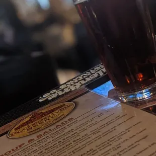 a menu and a glass of beer