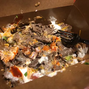 ows a fork in a box of food