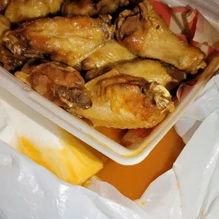 a plastic container filled with chicken wings