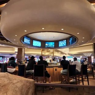 people sitting at the bar and watching televisions