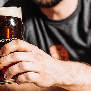 a man holding a pint of beer