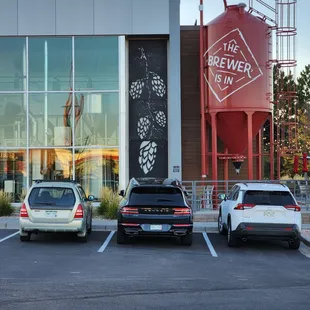 three cars parked in front of a brewery
