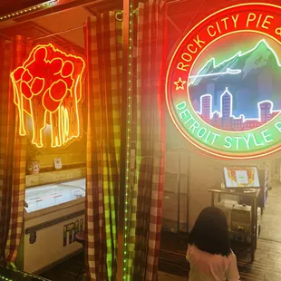 a woman standing in front of a neon sign