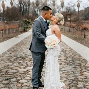 bride and groom kissing on cobblestone path