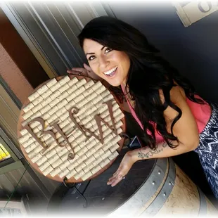 a woman holding a barrel of wine