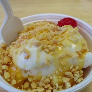 Butterscotch ice cream sundae with nuts and a cherry.