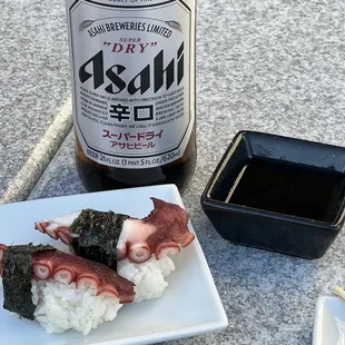 a plate of sushi and a bottle of beer