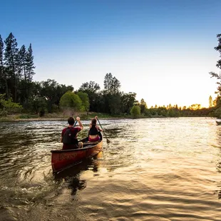 campers paddling a canoe into the sunset at a weekend marriage retreat