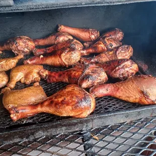chicken and chicken legs cooking on the grill