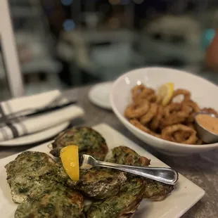 a plate of oysters and a bowl of onion rings