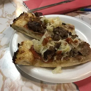 Meat pizza topped with sauerkraut and hot sauce!