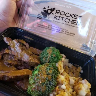 a hand holding a container of food