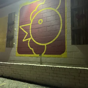 a red and yellow sign on a brick wall