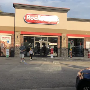 two people walking out of a restaurant