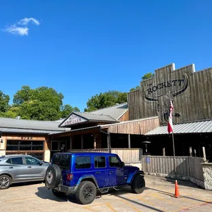 a blue jeep parked in front of the restaurant
