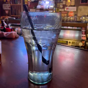 a glass of water with a spoon in it