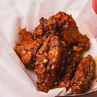 a basket of chicken wings and a drink