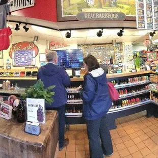 A panoramic view of the order counters. Lots of sauce for sale. The dining area is to the left.