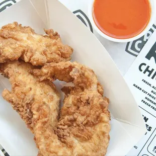 a tray of fried chicken and fries