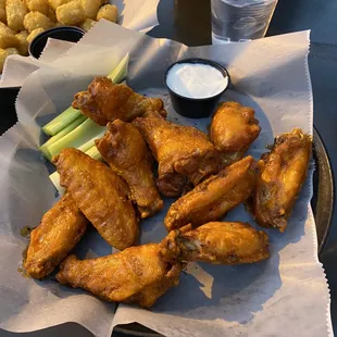 a plate of chicken wings and celery sticks