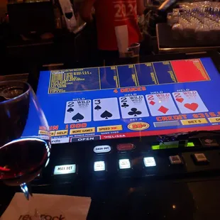 a glass of wine and a casino card game