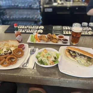 Brisket sandwich, Philly sub, side salad, wings, and onion rings.