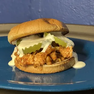 a chicken sandwich on a blue plate