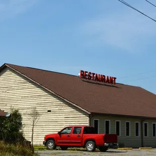 a red truck parked in front of the restaurant