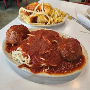 Spaghetti and meatballs with Macaroni and cheese in the background.