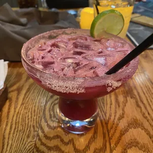 a margarita in a glass with a lime wedge
