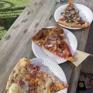 three slices of pizza on paper plates