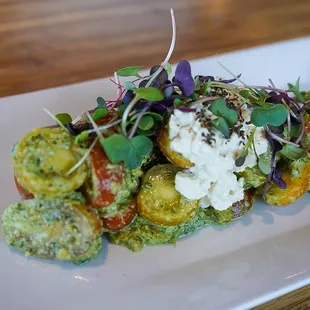 Heirloom Tomato Caprese, heirloom cherry tomatoes, pistachio pesto, cashew ricottta, basil